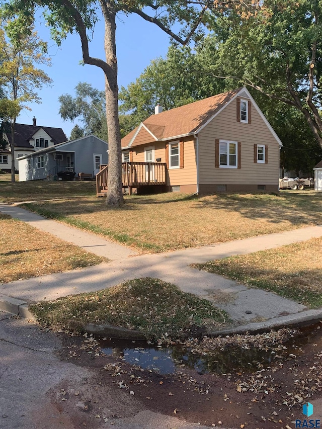 view of front of home with a wooden deck and a front lawn