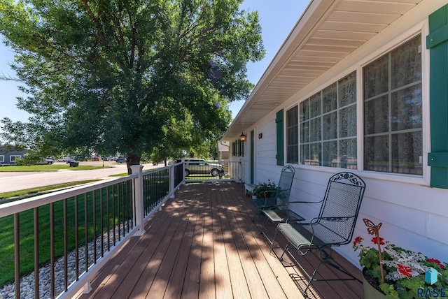 wooden deck featuring a lawn