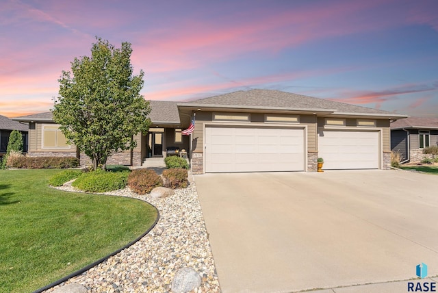 prairie-style home with a yard and a garage