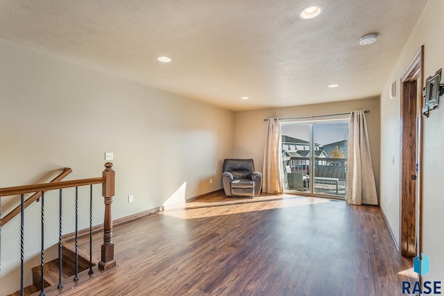 living area featuring wood-type flooring and a textured ceiling