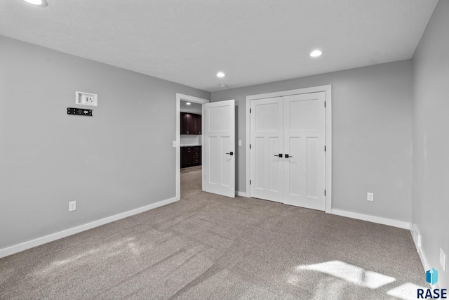 unfurnished bedroom featuring carpet floors and a closet