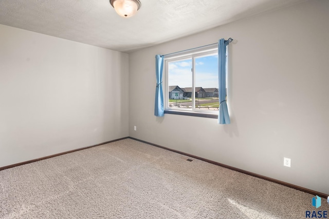 unfurnished room with carpet floors and a textured ceiling