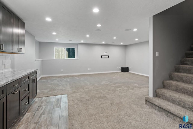 basement with light colored carpet and a textured ceiling