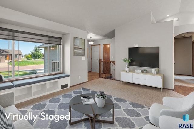 carpeted living room with vaulted ceiling