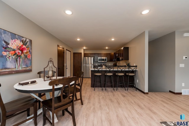 dining space with light wood-type flooring and sink