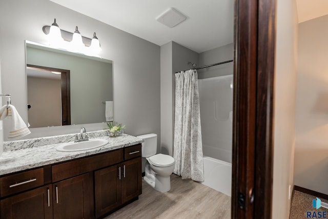 full bathroom with vanity, hardwood / wood-style floors, toilet, and shower / bath combo