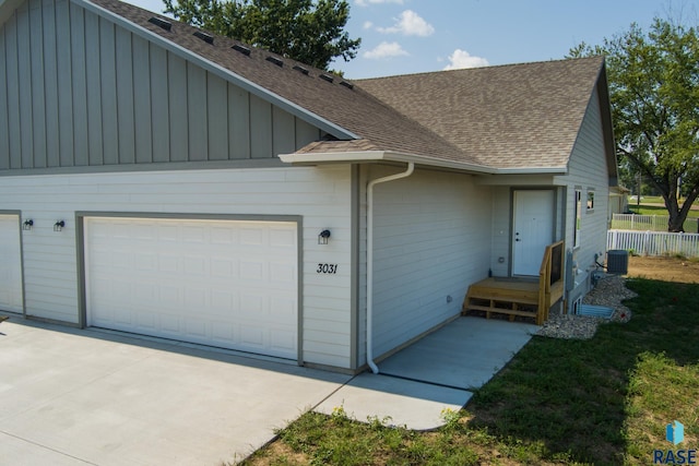 view of front of home with central AC unit and a garage