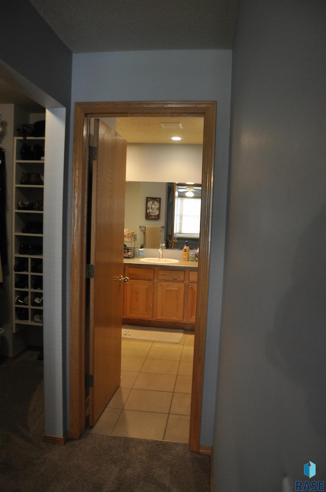 hall featuring light carpet and sink