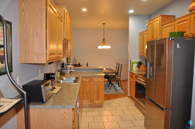 kitchen with sink, decorative light fixtures, light hardwood / wood-style flooring, stainless steel appliances, and a notable chandelier