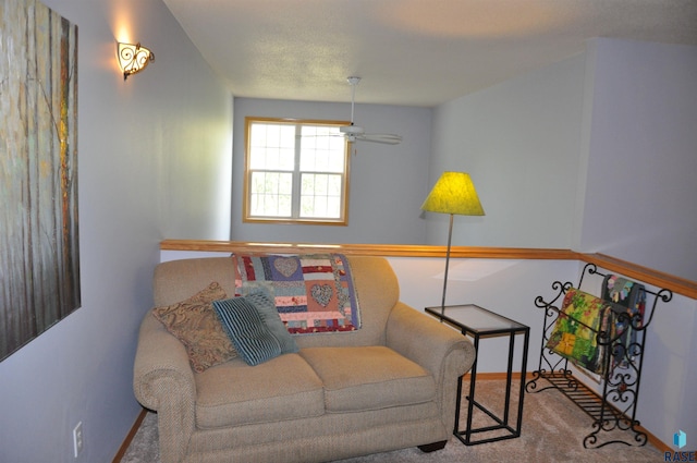 living area with ceiling fan and carpet