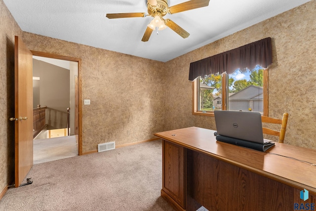 unfurnished office with a textured ceiling, light carpet, and ceiling fan