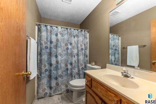 bathroom with toilet, vanity, and a textured ceiling