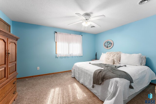 carpeted bedroom with a textured ceiling and ceiling fan