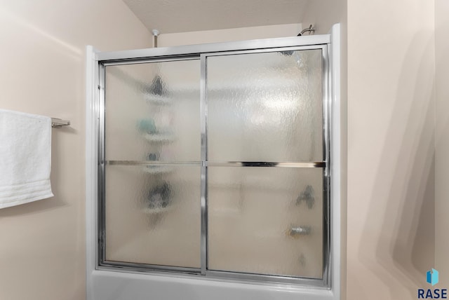 bathroom with shower / bath combination with glass door