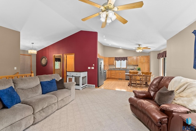 living room featuring light wood-type flooring, ceiling fan, sink, and vaulted ceiling