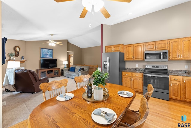 dining space featuring light hardwood / wood-style floors, lofted ceiling, and ceiling fan