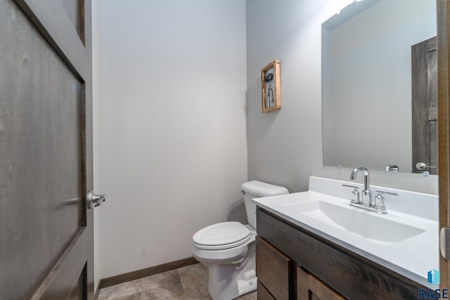 bathroom with tile patterned flooring, vanity, and toilet