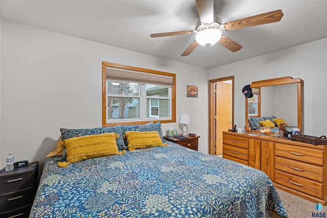 bedroom featuring ceiling fan, carpet floors, and a textured ceiling