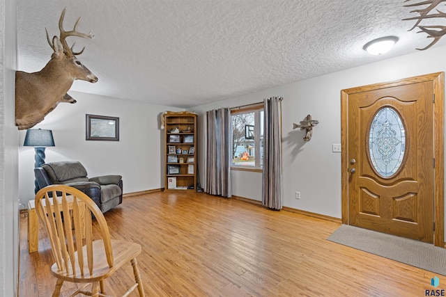 entrance foyer with light hardwood / wood-style floors and a textured ceiling