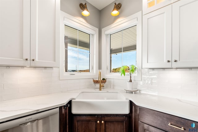 kitchen with white cabinetry, light stone countertops, sink, and dishwasher