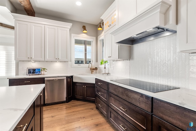 kitchen with black electric stovetop, sink, light wood-type flooring, stainless steel dishwasher, and custom range hood