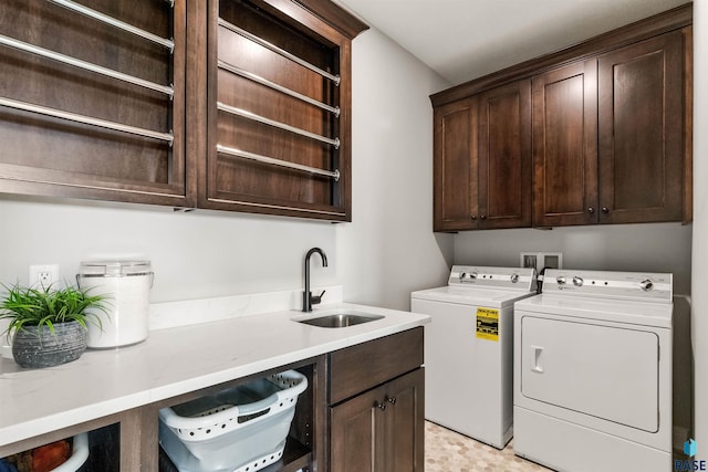 washroom with sink, independent washer and dryer, and cabinets