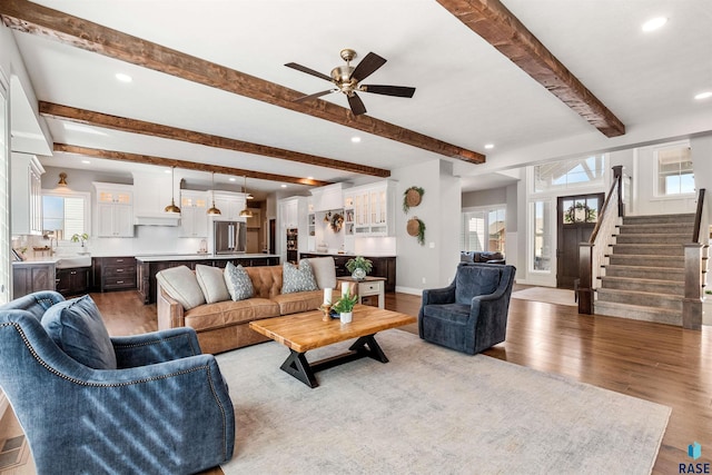 living room with beam ceiling, light hardwood / wood-style floors, and ceiling fan