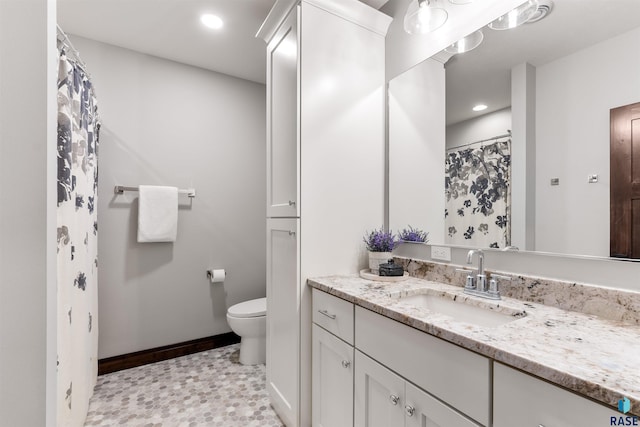 bathroom featuring toilet, vanity, and tile patterned flooring