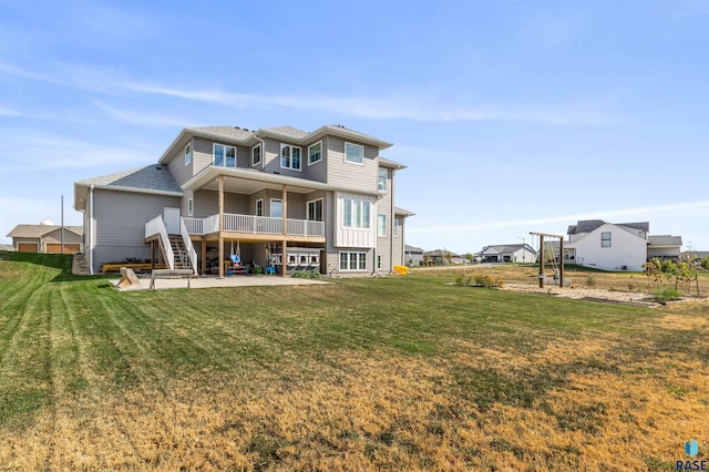 back of property featuring a yard, a patio area, and a wooden deck