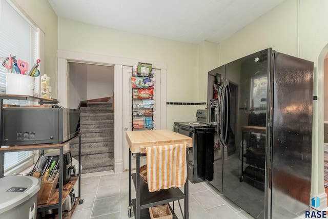 kitchen with black appliances and light tile patterned floors