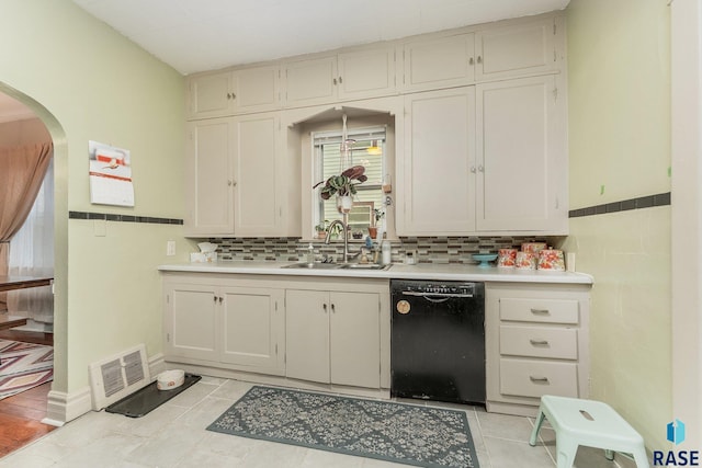 kitchen featuring dishwasher, backsplash, sink, light tile patterned floors, and white cabinets