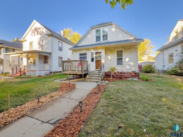 bungalow-style house featuring covered porch and a front lawn