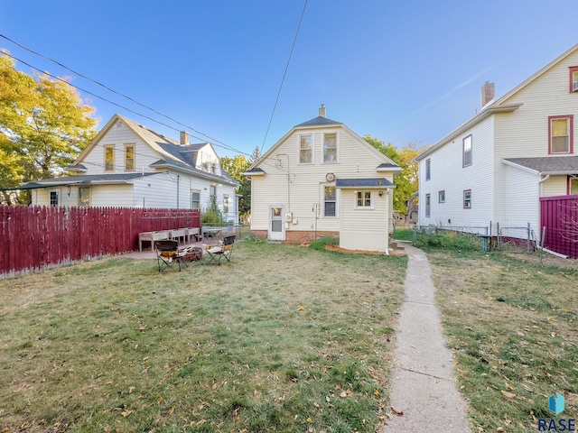 rear view of property with a lawn