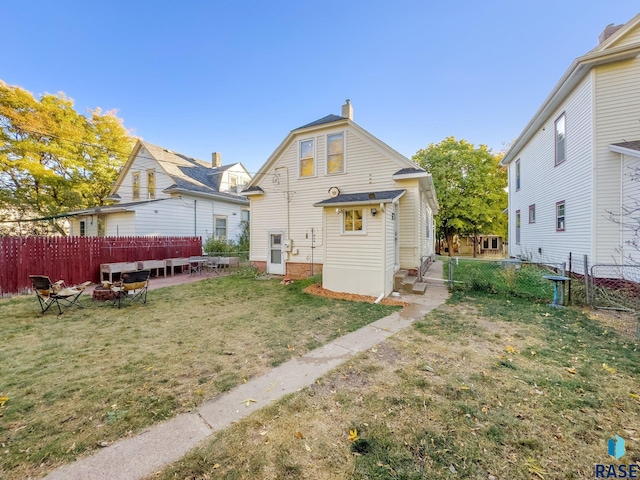 rear view of house with a patio area and a lawn