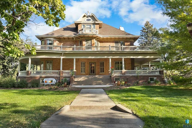 victorian home featuring covered porch and a front yard