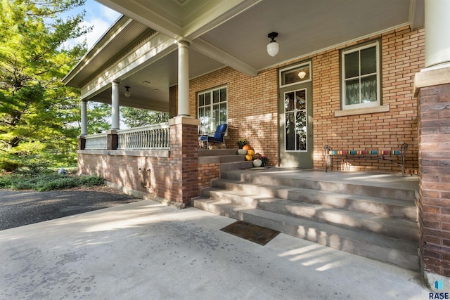 view of exterior entry featuring covered porch