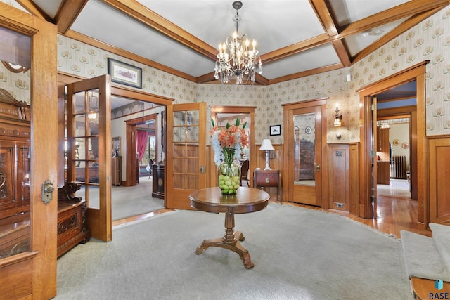 entrance foyer with coffered ceiling, french doors, beam ceiling, light colored carpet, and an inviting chandelier