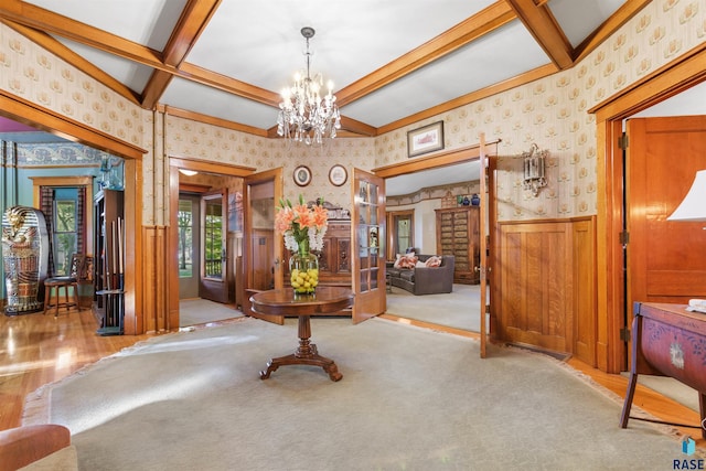 interior space with vaulted ceiling with beams, a chandelier, and light wood-type flooring