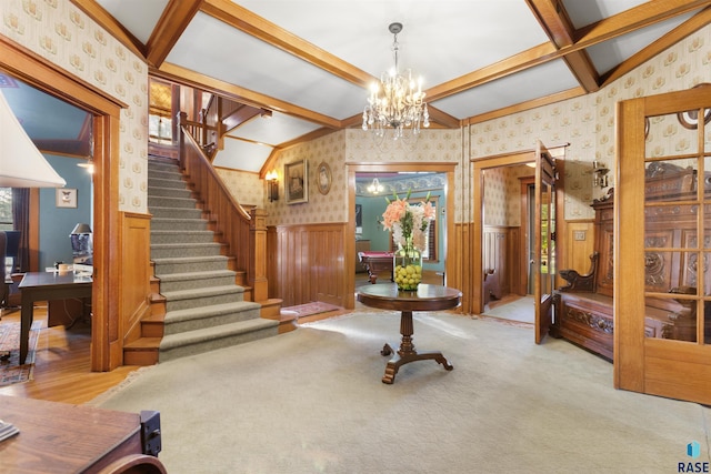 carpeted entryway with vaulted ceiling with beams and a notable chandelier