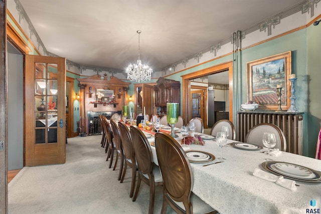 dining room featuring a notable chandelier and light colored carpet