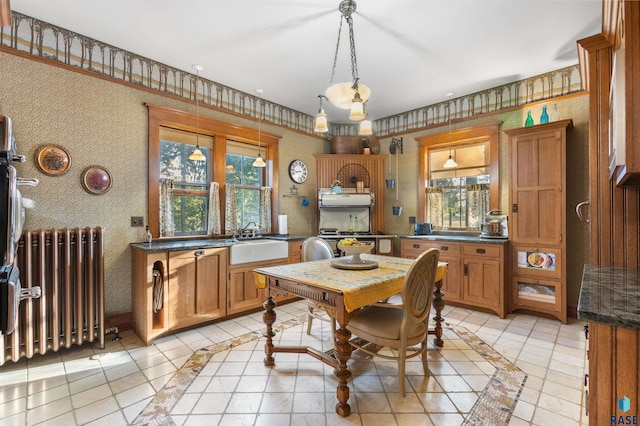 dining area with a wealth of natural light, sink, light tile patterned floors, and radiator