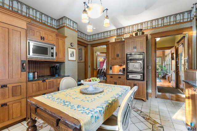 kitchen featuring light hardwood / wood-style flooring, stainless steel microwave, decorative light fixtures, and a kitchen island