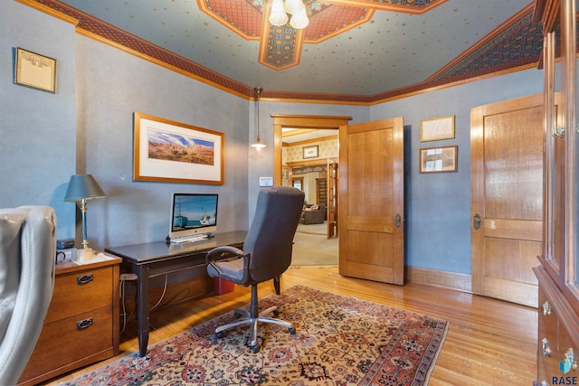 office with lofted ceiling, crown molding, and light hardwood / wood-style floors