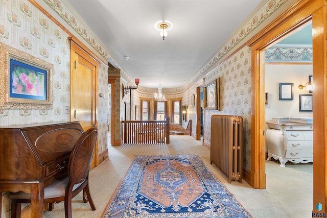 hall featuring ornamental molding, radiator heating unit, light colored carpet, and an inviting chandelier