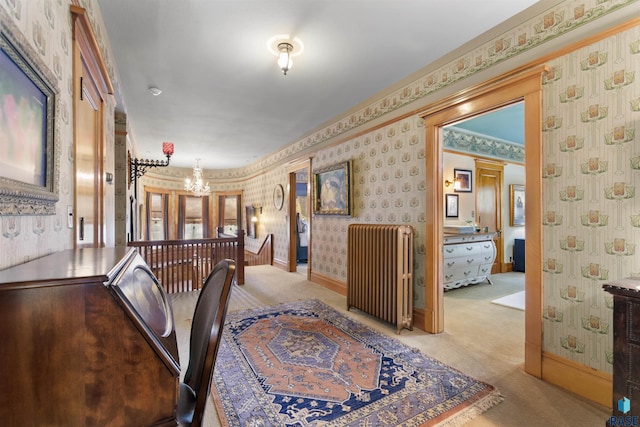 hallway with an inviting chandelier and light colored carpet