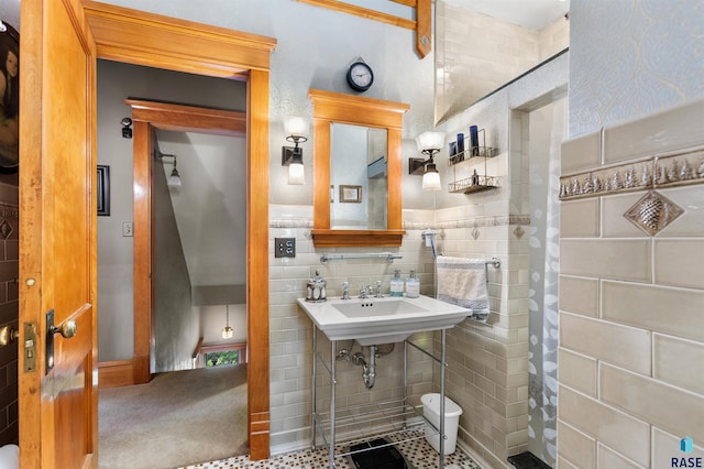 bathroom featuring sink and tile walls