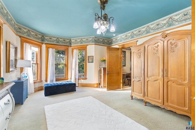 carpeted bedroom featuring crown molding and a notable chandelier