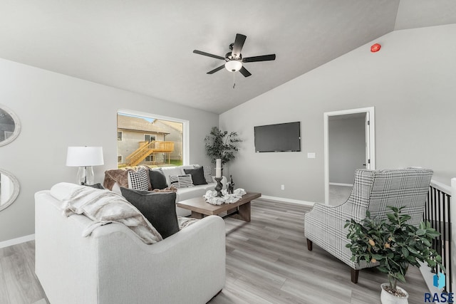 living room featuring lofted ceiling, light wood-type flooring, and ceiling fan