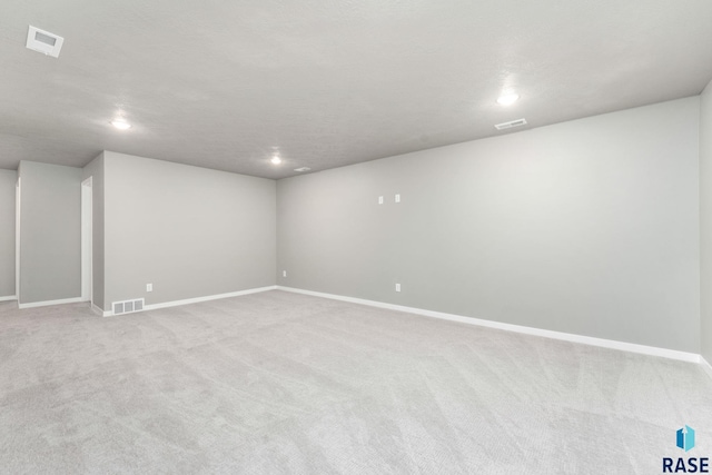 basement with light carpet and a textured ceiling