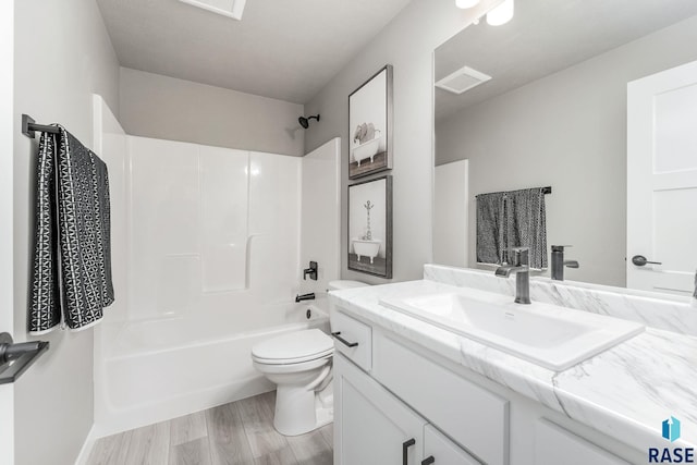 full bathroom featuring vanity, hardwood / wood-style flooring, toilet, and tub / shower combination